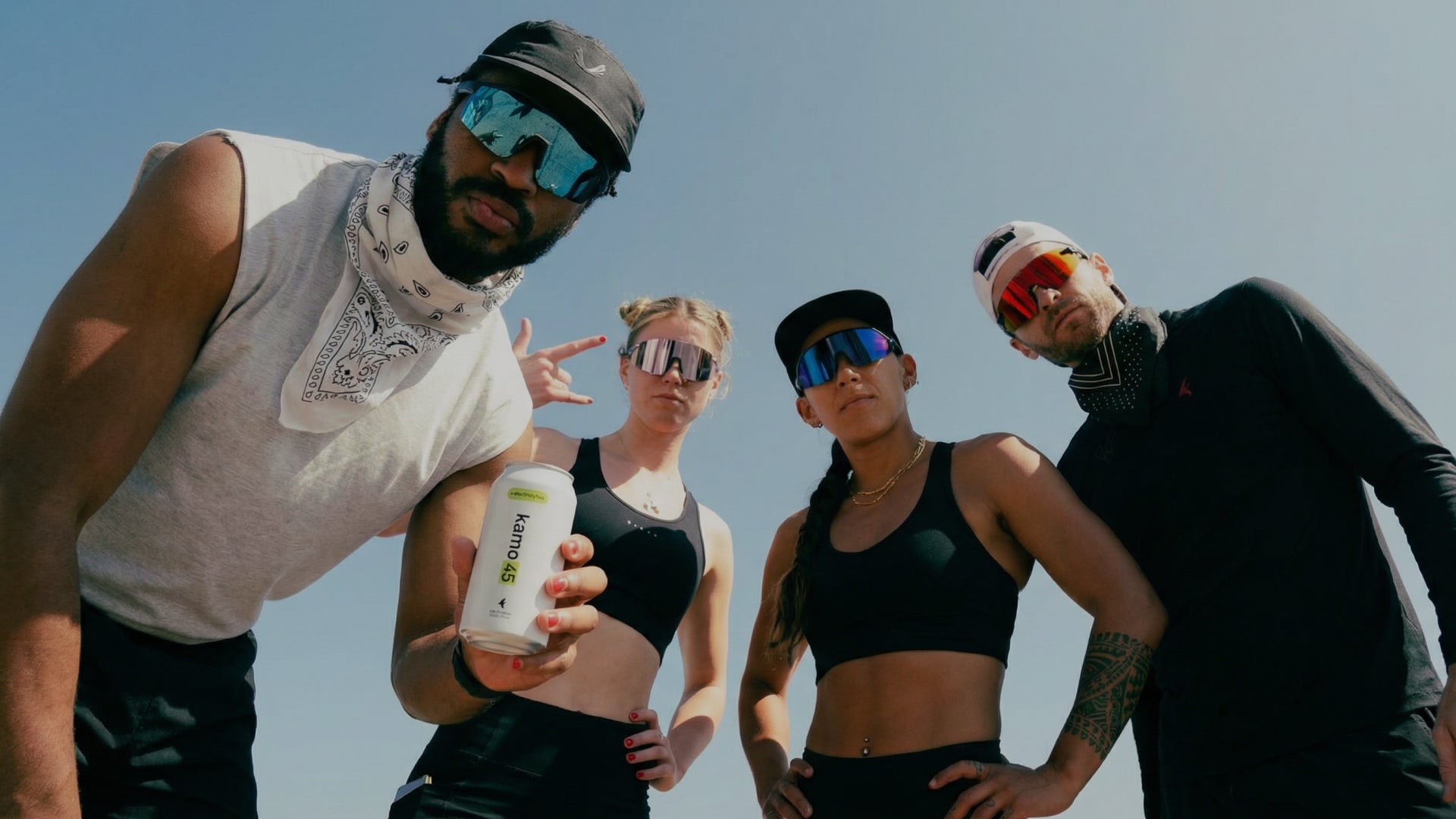 four athletes holding a kamo 45 alcohol free beer can outdoors